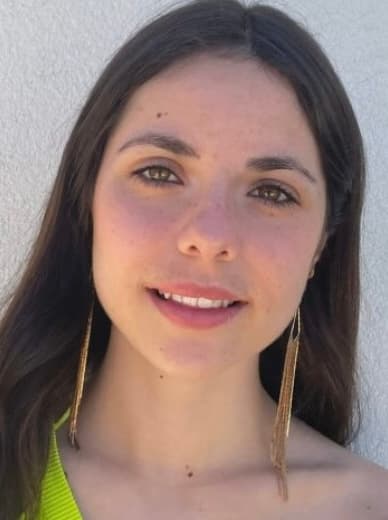 Headshot of Martina Belda Gutierrez, Fundraising and Sponsorship Coordinator at NeuroSol, smiling outdoors in a lime green top with gold earrings